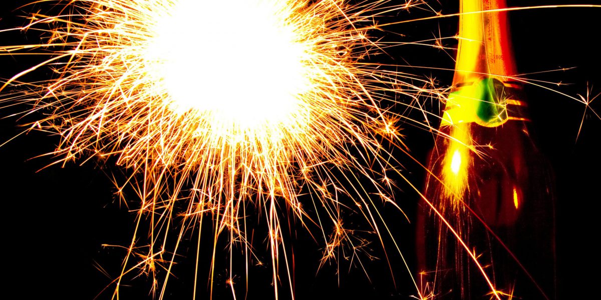 A bottle of champagne with fireworks