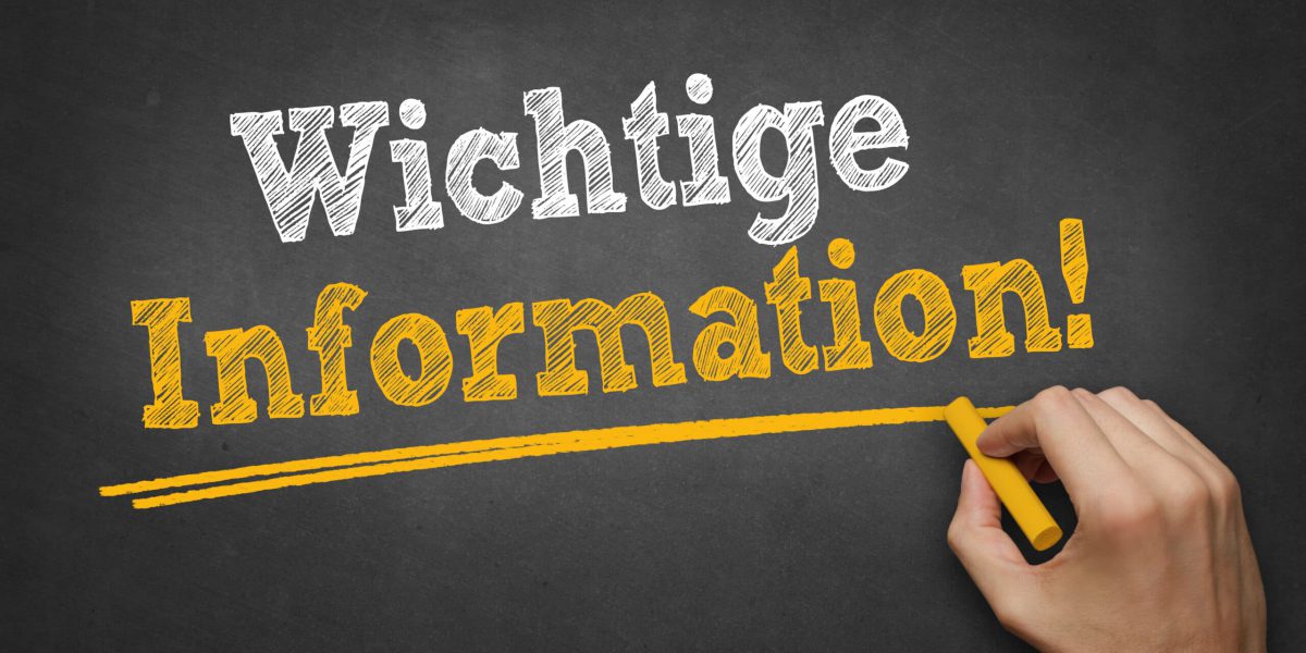 Hand schreibt Text "Wichtige Information" auf Kreidetafel